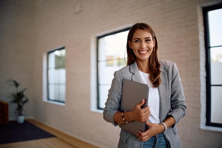 Foto retrato de uma jovem mulher de negócios feliz no escritório olhando para a câmera