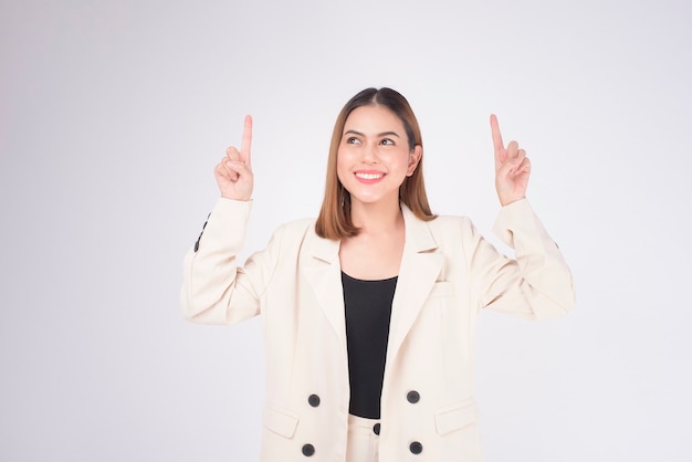 Retrato de uma jovem mulher de negócios linda vestindo terno no estúdio de fundo branco.