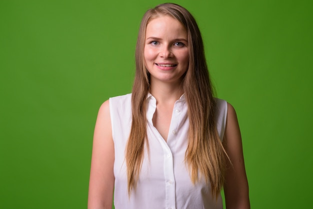 Retrato de uma jovem mulher de negócios loira bonita em verde