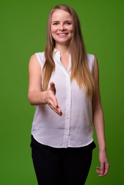 Retrato de uma jovem mulher de negócios loira bonita em verde