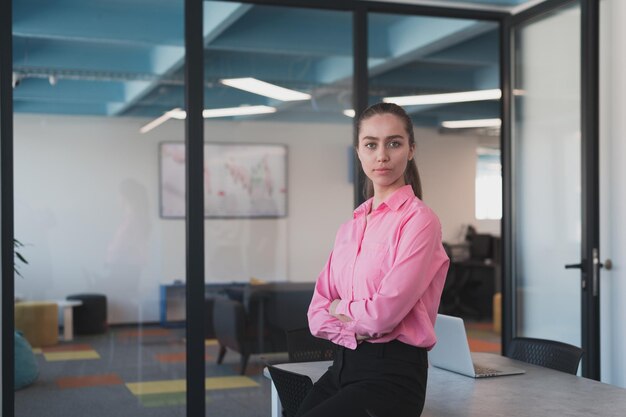 Retrato de uma jovem mulher de negócios sorridente no escritório de inicialização de coworking de espaço aberto criativo. Empresária bem-sucedida no escritório com copyspace. Colegas de trabalho trabalhando em segundo plano.