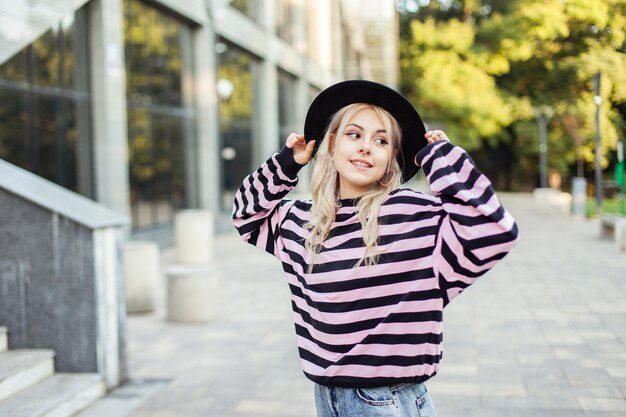 Retrato de uma jovem mulher encantadora em um suéter e chapéu ao ar livre