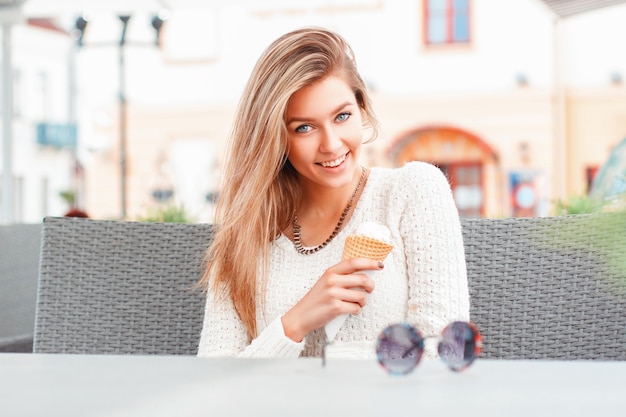 Retrato de uma jovem mulher feliz comendo sorvete ao ar livre