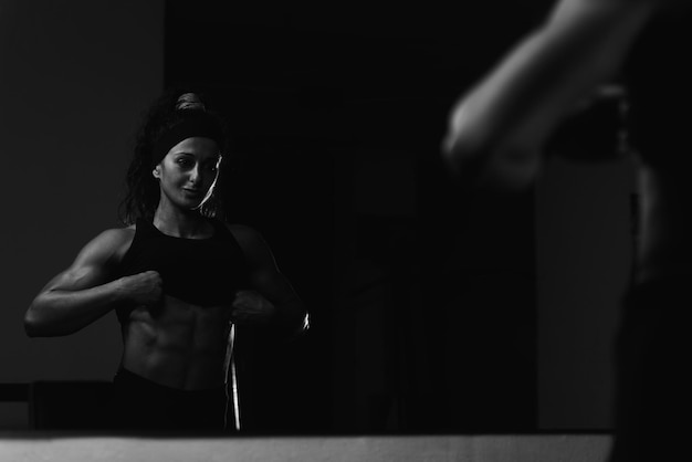 Retrato de uma jovem mulher fisicamente apta mostrando seu corpo bem treinado Muscular Atlético Bodybuilder Fitness modelo posando após exercícios
