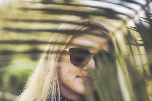 Foto retrato de uma jovem mulher junto a uma palmeira