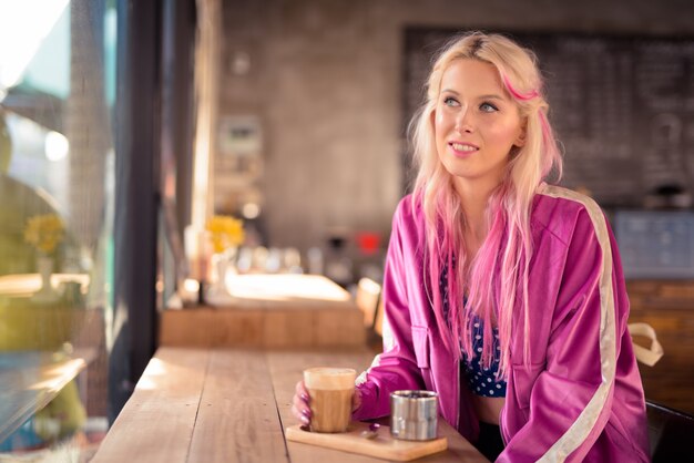 Retrato de uma jovem mulher loira bonita relaxando na cafeteria