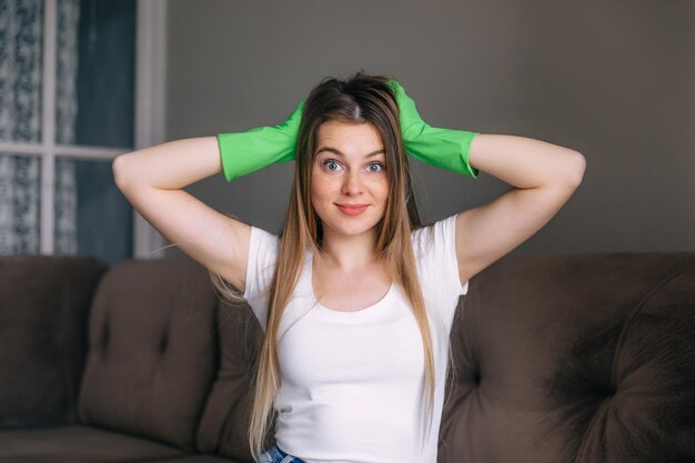 Retrato de uma jovem mulher maravilhada olhando para a câmera usando luvas de proteção e segurando a cabeça