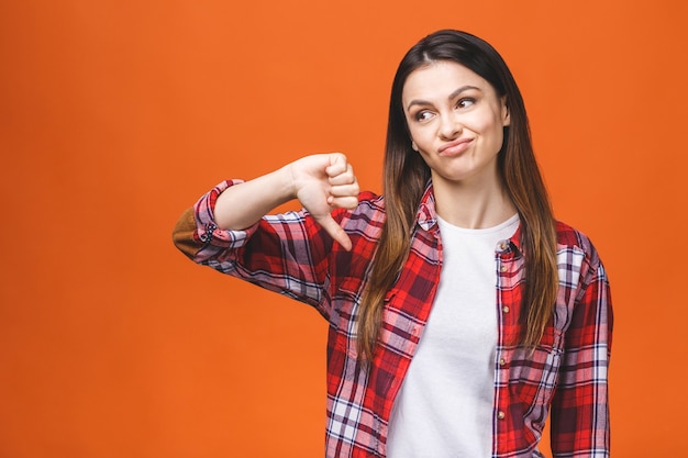 Retrato de uma jovem mulher mostrando um gesto de polegar para baixo