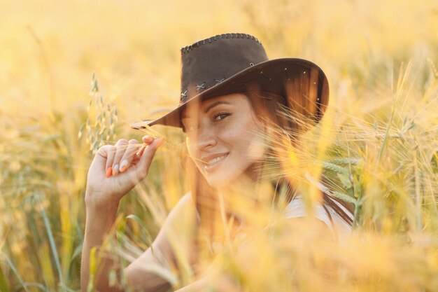 Retrato de uma jovem mulher olhando para longe enquanto estava sentada no campo