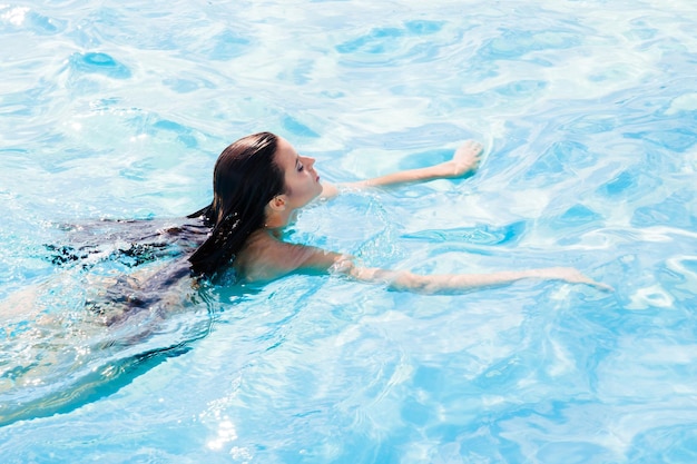 Retrato de uma jovem nadando na piscina