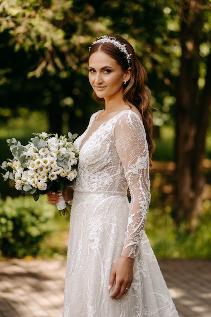 Retrato de uma jovem noiva em um vestido de noiva elegante com uma bela maquiagem e penteado