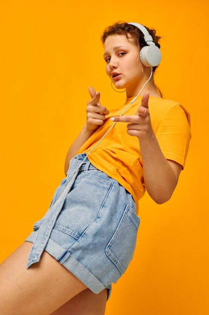 Retrato de uma jovem ouvindo música em fones de ouvido estilo jovem vista cortada inalterada