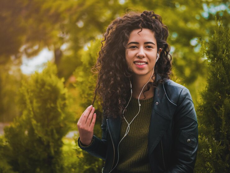 Foto retrato de uma jovem ouvindo música junto a plantas