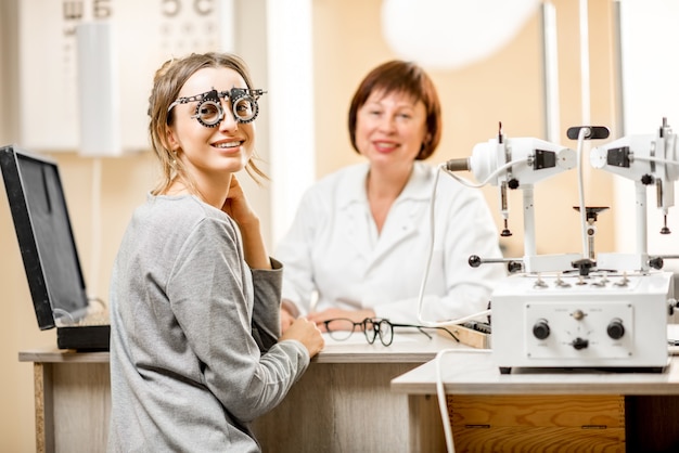 Retrato de uma jovem paciente com oftalmologista sênior durante a consulta no consultório