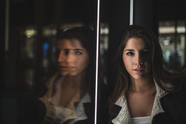 Foto retrato de uma jovem pela janela de vidro