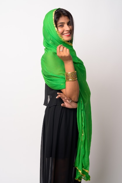 Retrato de uma jovem persa linda vestindo roupas tradicionais contra uma parede branca