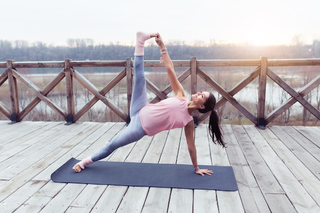 Retrato de uma jovem praticando ioga ao ar livre na natureza