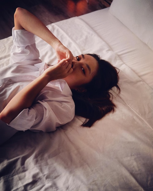 Retrato de uma jovem relaxando na cama em casa