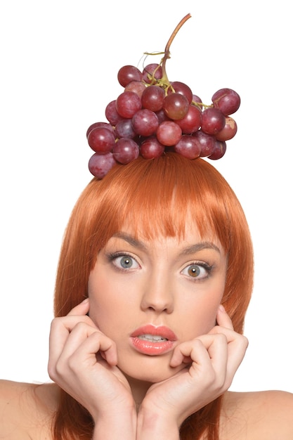 Retrato de uma jovem ruiva com uvas vermelhas na cabeça