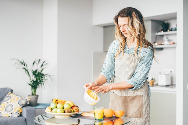 Retrato de uma jovem segurando frutas em casa