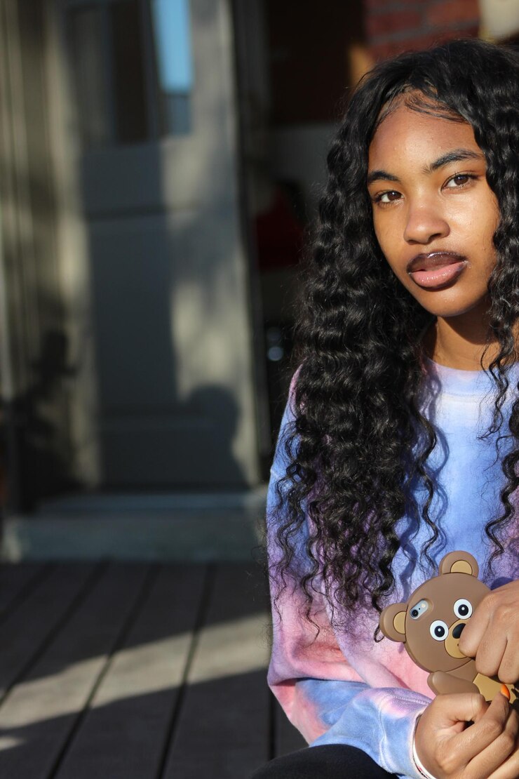 Foto retrato de uma jovem segurando um brinquedo enquanto estava sentada na varanda