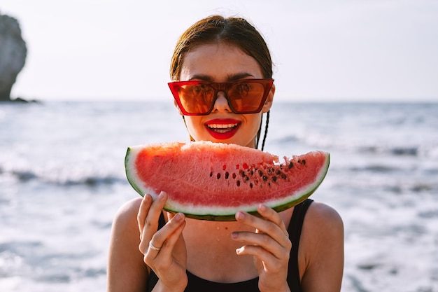 Foto retrato de uma jovem segurando uma bebida na praia