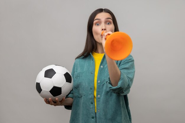 Foto retrato de uma jovem segurando uma bola de futebol contra um fundo branco