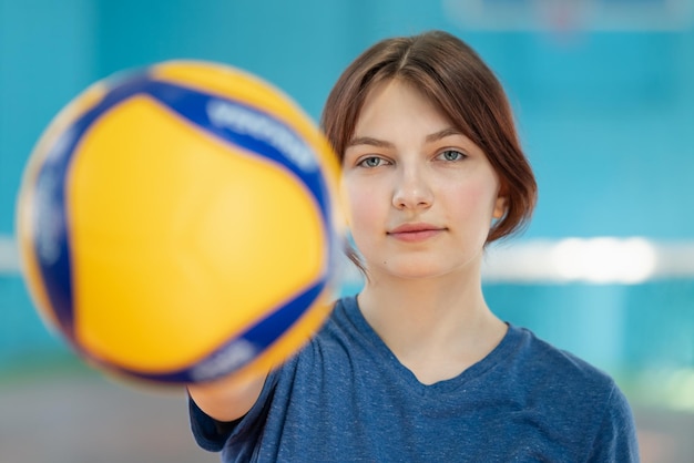 Retrato de uma jovem segurando uma bola de vôlei Conceito de treinamento de vôlei garota esportiva mostrando uma nova bola para a câmera