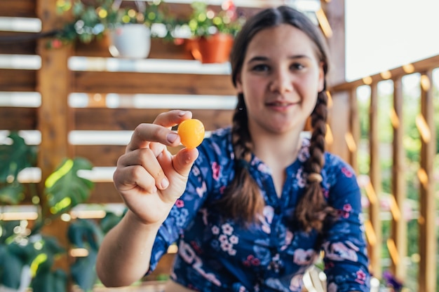 Retrato de uma jovem segurando uma fruta