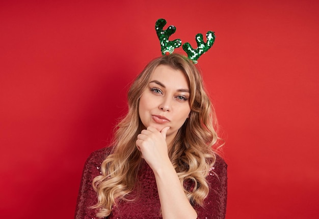 Retrato de uma jovem senhora bonita com fita de Natal isolada em fundo vermelho