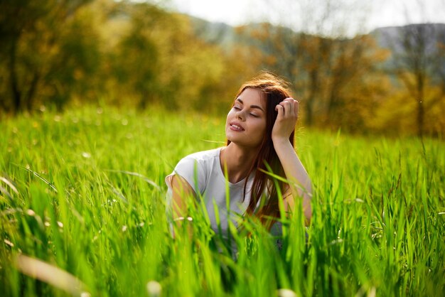 Foto retrato de uma jovem sentada em um campo gramado