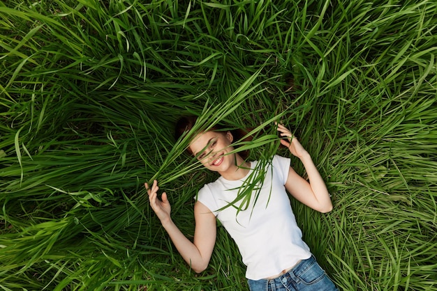 Foto retrato de uma jovem sentada em um campo gramado