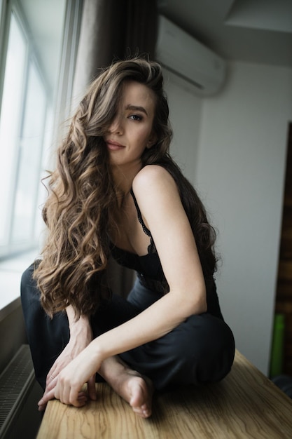 Retrato de uma jovem sentada em uma mesa em casa