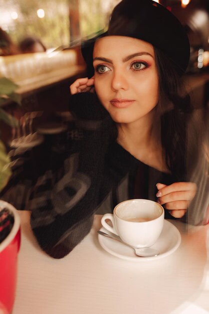 Foto retrato de uma jovem sentada em uma mesa