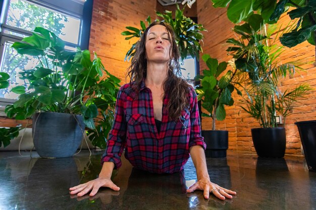 Foto retrato de uma jovem sentada em uma planta em vaso em casa