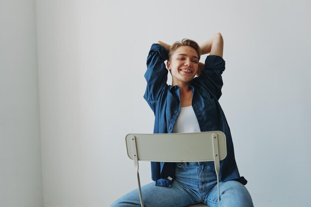 Foto retrato de uma jovem sentada no sofá contra a parede