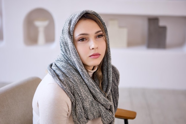 Retrato de uma jovem sentada no sofá em casa