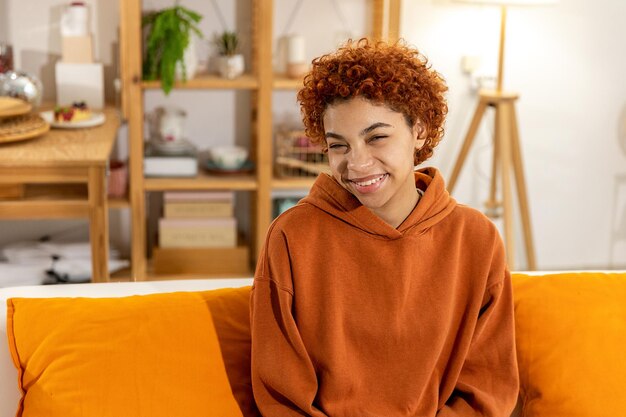 Foto retrato de uma jovem sentada no sofá em casa