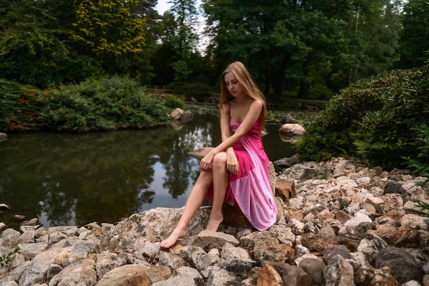 Retrato de uma jovem solitária elegante na natureza como papel de parede, fundo, cartaz, capa de revista