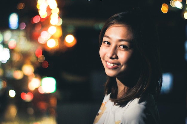 Retrato de uma jovem sorridente à noite