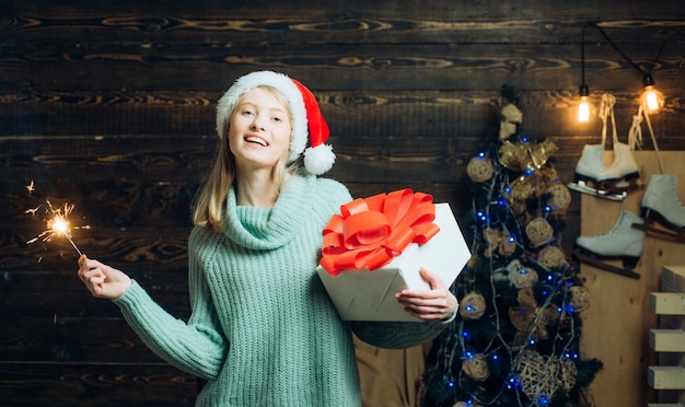 Retrato de uma jovem sorridente alegre jovem vestindo fantasia de Natal sobre a parede de madeira.