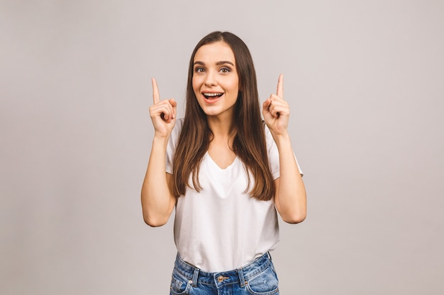 Retrato de uma jovem sorridente apontando o dedo para cima