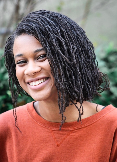 Retrato de uma jovem sorridente com dreadlocks