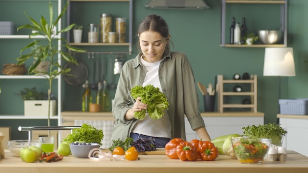 Retrato de uma jovem sorridente com um pacote de salada nas mãos em pé