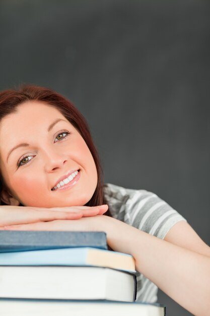 Foto retrato de uma jovem sorridente confiando em seus livros