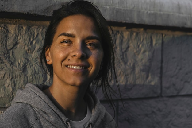 Foto retrato de uma jovem sorridente contra a parede