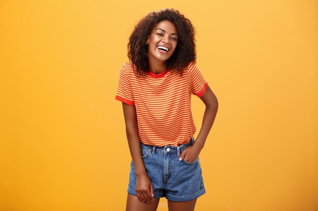 Foto retrato de uma jovem sorridente contra um fundo amarelo