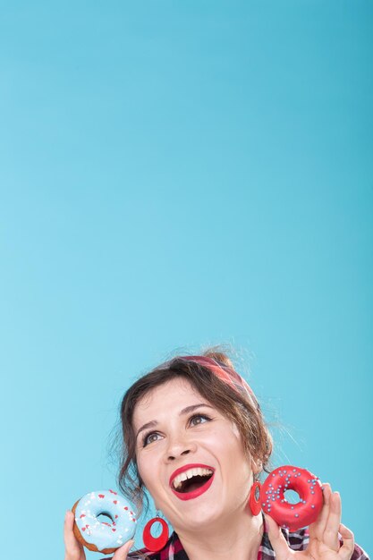 Foto retrato de uma jovem sorridente contra um fundo azul