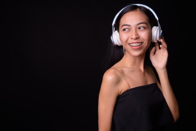 Foto retrato de uma jovem sorridente contra um fundo preto