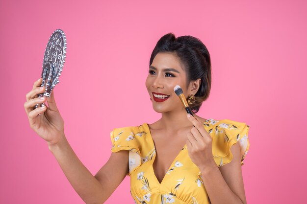 Foto retrato de uma jovem sorridente contra um fundo rosa